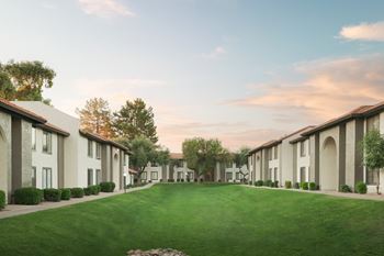 Lush landscaping with green lawns and trees throughout